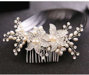 Macro detail of silver bridal hair comb with pearls and rhinestones on dark background