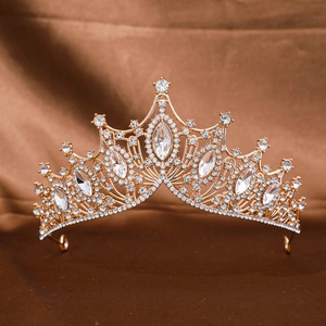 Detailed view of Baroque gold crown with large marquise rhinestones on a satin background