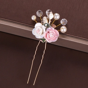 Detail of handmade bridal hair pin with ceramic roses, pearls, and golden leaf accents