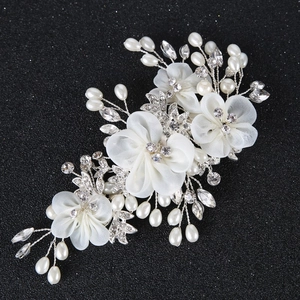 Elegant bridal hair clip with white silk flowers pearls and crystals on black background