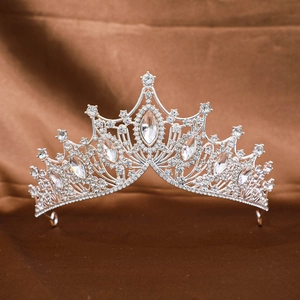 Macro view of silver baroque tiara with marquee crystals on brown satin background
