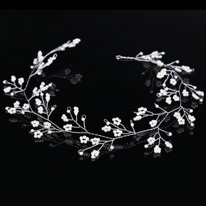 Elegant silver bridal hair vine with white pearls and flower patterns on black background