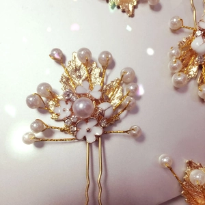 Braut Haarnadel in Gold mit Emaille-Blumen und Perlen auf rosa Hintergrund