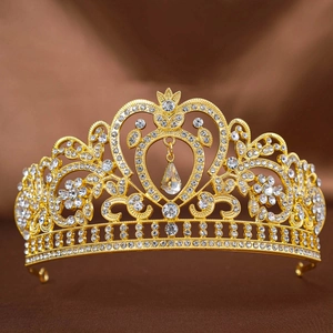 Detail of golden Baroque bridal crown with heart-shaped design and teardrop crystal