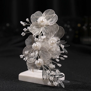 Exquisite bridal wrist corsage with white flowers, silver wire petals, and pearls