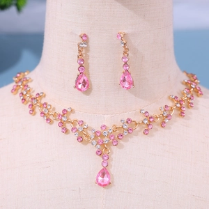 Nahaufnahme von Brautschmuckset in Roségold mit rosa Kristalltropfen auf einem Display