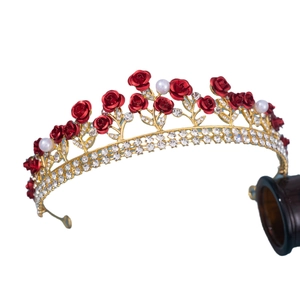 Golden bridal crown with red roses, clear rhinestones and pearls on a white background