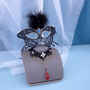 Macro shot of gothic lace mask and choker set with blue gemstones and black feathers