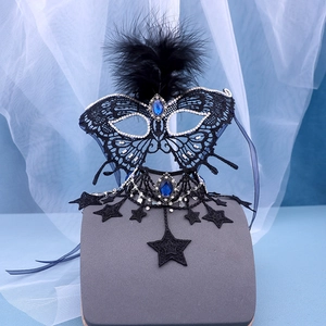 Detailed close-up of a black lace masquerade mask and choker set with blue gemstones