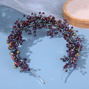 Detail of handmade beaded bridal headband with dark red crystals and woven wire
