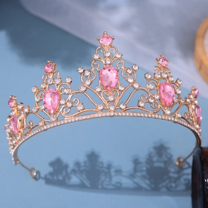 Close-up of golden bridal tiara with pink teardrop crystals and white rhinestones