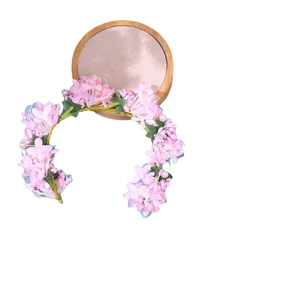 Pink fabric flower bridal headband with pearls and gold wire on a wooden base