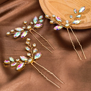 Set di tre forcine da sposa dorate con strass a marquise su uno sfondo di seta marrone