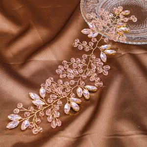Handmade bridal headband with pink crystals and gold wire on brown silk fabric