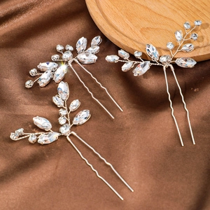 Dettaglio delle forcine da sposa argentate con strass luccicanti e design a foglia