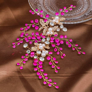 Détail de la vigne de cheveux de mariée dorée avec strass rose rouge et perles blanches