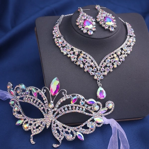 Détail de parure bijoux en strass avec masque papillon et collier sur fond de soie