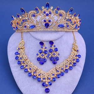 Detalle del conjunto de tiara y collar de novia dorado con cristales azul real