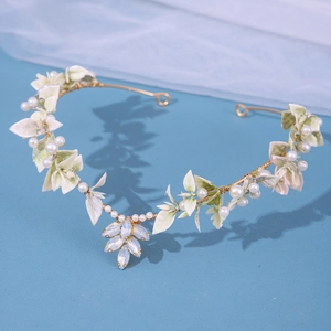 Eleganter goldener Brauthaarschmuck mit grünen Blättern, Perlen und blauem Kristall