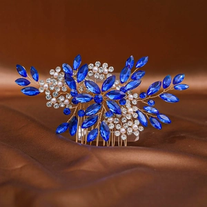 Détail d'un peigne à cheveux de mariée avec strass bleus et perles sur fond de satin