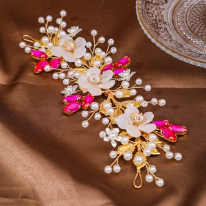 Close-up of handmade bridal headband with gold wires, white flowers and pink crystals