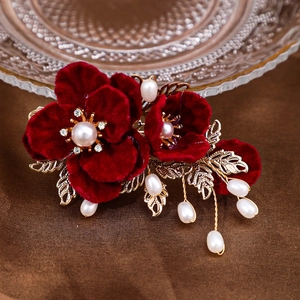 Pince à cheveux camélia rouge en velours avec perles et strass sur feuilles dorées
