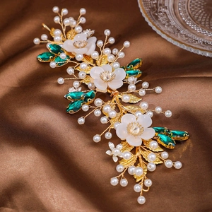 Handmade bridal hairpiece with pearls, green gemstones, and resin flowers on gold wire