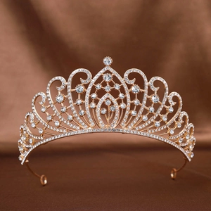 Detailaufnahme einer goldenen Brautkrone mit funkelnden weißen Strasssteinen auf brauner Seide