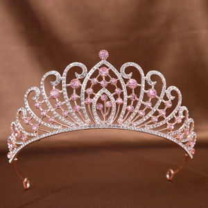Nahaufnahme einer roségoldenen Hochzeit Krone mit rosa Strasssteinen auf Samtstoff