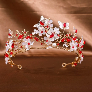 Detail of bridal crown with gold butterfly, red marquise crystals and white flowers