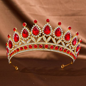 Close-up of Baroque gold crown with red pear-shaped rhinestones on dark silk