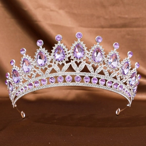 Detail of silver crown featuring purple teardrop crystals and white rhinestones