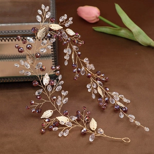 Handmade bridal headband with golden leaves and purple beads on a velvet background
