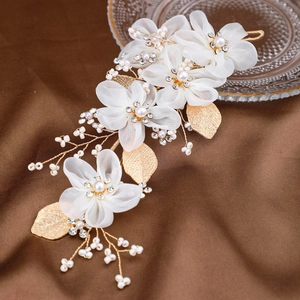 Coiffe de mariée élégante avec fleurs en tulle blanc, perles et feuilles dorées sur soie