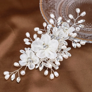Détail d'un peigne à cheveux mariée avec fleurs en maille, perles et cristaux