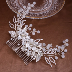 Détail d'un peigne à cheveux de mariée avec fleurs argentées, perles et cristaux brillants