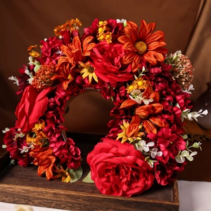 Dettaglio corona di fiori rossi fatti a mano con margherite arancioni per acconciature