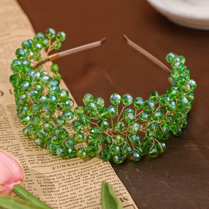 Handcrafted bridal headband with woven emerald green crystals on a gold wire frame