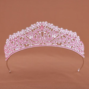 Macro detail of silver bridal tiara featuring pink rhinestones and floral alloy patterns