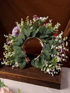 Dettaglio di un cerchietto floreale fatto a mano con margherite viola e fiori rosa