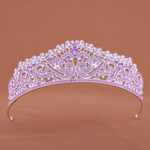 Detail shot of a silver-tone crown featuring purple rhinestones and intricate vortex patterns