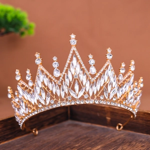 Exquisite goldene Brautkrone mit Marquise-Strasssteinen auf edlem Holztablett