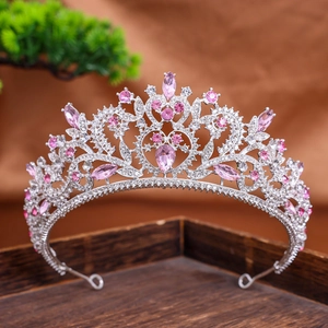 Macro detail of a silver-toned bridal tiara featuring pink rhinestones and scroll patterns