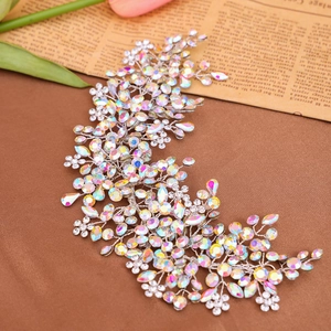 Macro detail of hand-woven bridal hair comb with shimmering rhinestones and silver leaves