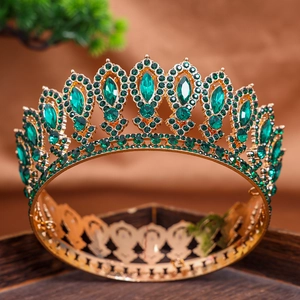 Detail of luxury baroque gold tiara featuring marquise green gemstones and sparkling rhinestones