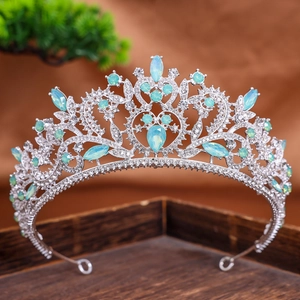Detail of baroque silver crown with blue teardrop rhinestones on dark wooden base