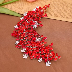 Macro shot of handmade silver wire bridal hair comb with red crystals and white rhinestones