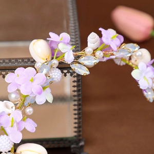 Detail of bridal headband with purple fabric flowers, sea shells and faux pearls