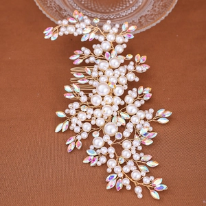 Dettaglio di un pettine da sposa fatto a mano con perle e cristalli su filo dorato