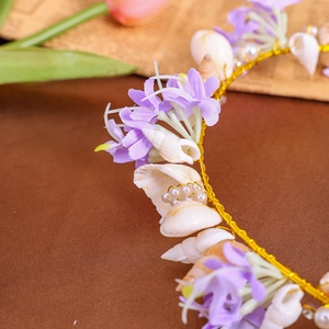 Detail of bohemian shell headband with purple flowers and pearls on golden wire